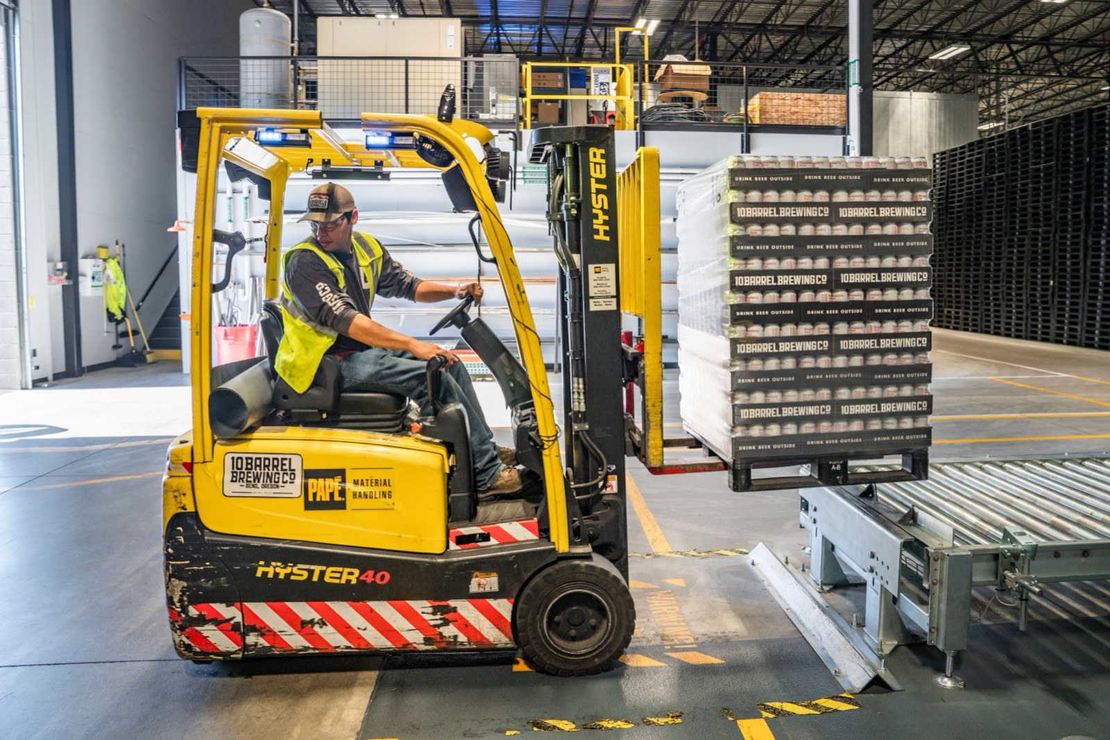 Forklift operator moving a load in a warehouse